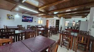 费德拉西翁Villa Termal的餐厅设有木桌、椅子和电视。
