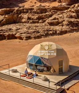 瓦迪拉姆MARS LUXURY CAMP WADi RUM的沙漠里的帐篷,里面的人