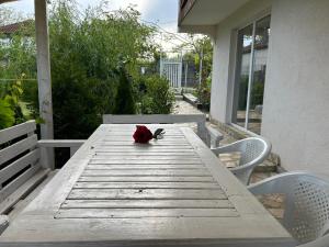 EzeretsSanny’s house的门廊上木桌边的红玫瑰