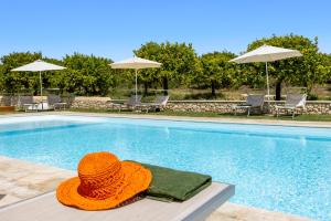 诺托Fiore di Vendicari - Near the beaches of Calamosche and Vendicari的坐在游泳池旁的橙色帽子