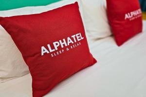 清迈Phu Jaya Floresta Resort by ALPHATEL的一张带两个红色枕头的床