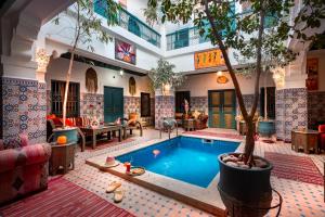 马拉喀什里亚德阿扎利亚酒店的一座建筑物中间有树的游泳池