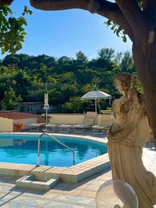伊斯基亚Resort Villa Flavio的一座带女人雕像的游泳池