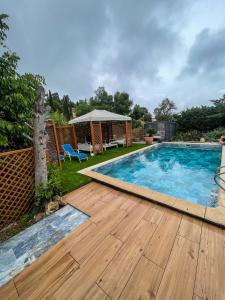 雷以桑布尔Villa “mas provençale”的庭院旁的一个带木甲板的游泳池