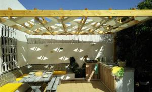 胡瓦里耶Dar Gitta & Wood El Haouaria的一个带桌子和木制凉亭的庭院