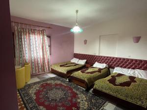 艾济拉勒Hotel Tanout的带三张床和镜子的客房