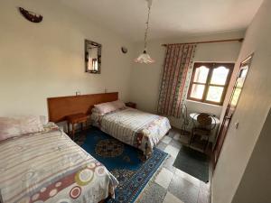 艾济拉勒Hotel Tanout的一间卧室设有两张床和窗户。