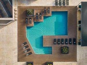梅里达凯悦梅里达酒店的享有带长椅和椅子的游泳池的顶部景致