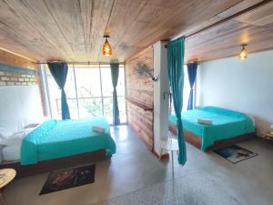 圣玛尔塔Casa Pistacho的一间卧室设有两张床和一个壁炉
