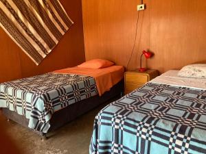 帕拉卡斯Paracas Camp Lodge & Experiences的一间卧室配有两张床和床头灯。