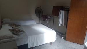 耶尔瓦布埃纳Rincón Colombiano的卧室配有白色的床和风扇