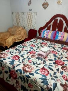 利马Posada Ternura的一间卧室配有一张带花卉棉被的床