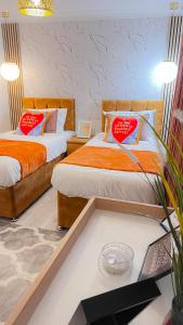 巴塞尔顿Luxury 2-Bedroom House - Smart Home - Basildon Serviced Accommodation - 6Mins Walk To Basildon Town Centre, Hospital & Train Station的客房内的两张床和红色枕头