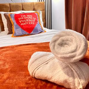 巴塞尔顿Luxury 2-Bedroom House - Smart Home - Basildon Serviced Accommodation - 6Mins Walk To Basildon Town Centre, Hospital & Train Station的床上有枕头,上面有毛巾