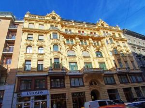布达佩斯Palace Apartment的一条城市街道上的黄色大建筑