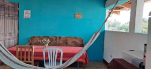 帕纳哈切尔Hostal Dulces Sueños的一张桌子旁的吊床和蓝色的墙壁