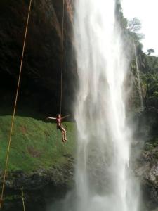 KapchorwaSipi Guest House的瀑布旁的绳索摆动者