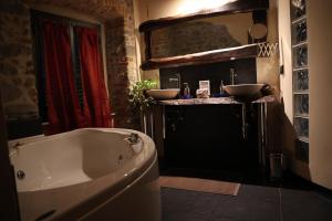 佩夏Mansarda Pescia的浴室配有浴缸和两个盥洗盆。