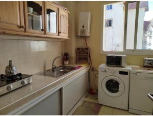 伊夫兰Bel appartement à Ifrane的厨房配有水槽和洗衣机
