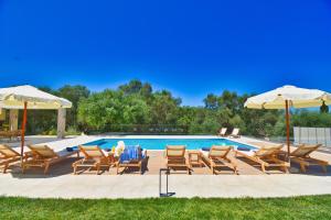 AlepochórionMinerva Estate Corfu的一组椅子和遮阳伞,位于游泳池旁