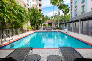 迈阿密Holiday Inn Miami-Doral Area, an IHG Hotel的一座游泳池,毗邻一座建筑,设有凉亭