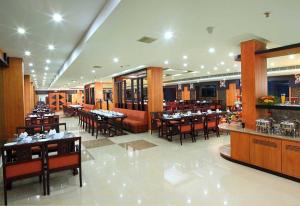 阿勒皮Haveli Backwater Resort的一间在房间内配有桌椅的餐厅