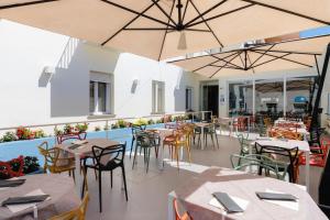 毕博纳的码头尼娜酒店的空荡荡荡的餐厅,配有桌椅和遮阳伞