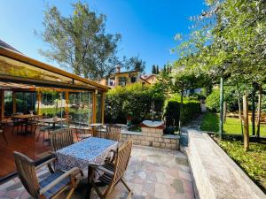 皮兰Villa Verde Piran, Authentic Mediterranean Stay的庭院配有桌子和一些椅子