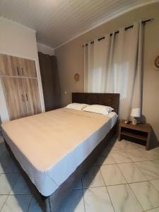 尼基亚娜Aggeliki Apartments的一间卧室配有一张大床和床头柜