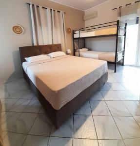 尼基亚娜Aggeliki Apartments的一间带两张双层床的卧室,铺有瓷砖地板。