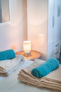 帕拉蒂Casa Surya Paraty的一间卧室配有一张带蓝色毛巾和一盏灯的床
