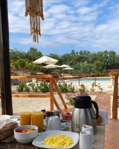 卡诺阿斯德蓬萨尔El Samay Hotel Boutique的一张带早餐食品的桌子,享有游泳池的景色