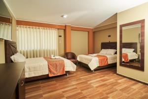 塔尔马Jeranco Hotel的酒店客房,设有两张床和镜子
