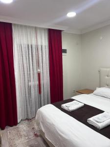 乌宗Kuzey Park Hotel的一间卧室配有床和红色窗帘