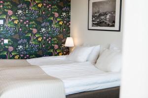 吕瑟希尔Villa Solviken的一间卧室配有一张带花卉壁纸的床