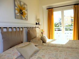圣埃乌拉利亚耶比萨旅舍的一间卧室设有一张床和一个窗口