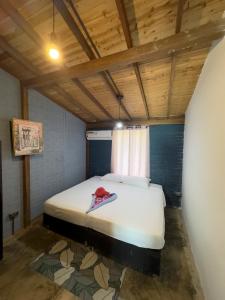 La LomaPOSADA MISS ANIBEL的一间带一张床的卧室,位于带木制天花板的房间内