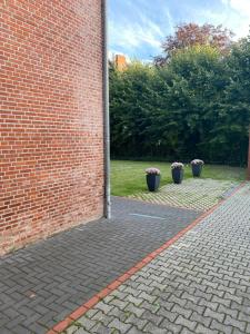 埃姆登Appartementhaus EMDEN的庭院里两棵盆栽植物的砖墙