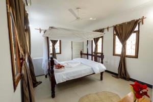 FujoniMangapwani Beach villa的一间卧室配有一张带天蓬的床