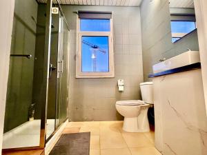 波尔图SwissPorto Guest House的带淋浴和卫生间的浴室以及窗户。