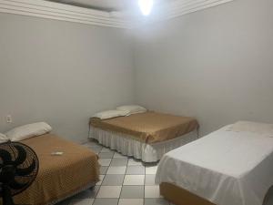 特雷西纳Casa Piauí Hostel的一间设有两张床和白色墙壁的客房