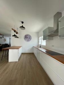 塔拉哈勒赫La Villa的厨房铺有木地板,配有白色橱柜。