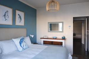 西蒙镇Penguin Paradise Apartment Simons Town的一间卧室配有一张蓝色墙床