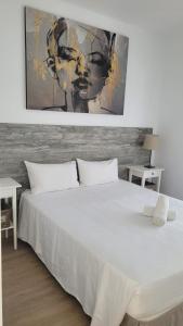 塔拉哈勒赫La Villa的卧室配有白色的床和墙上的绘画作品