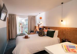 布里斯班LyLo Brisbane的两人坐在酒店房间的床边