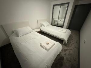 切姆3 Bed Penthouse in City Centre!的小型客房的两张床,配有镜子