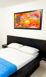 里奥阿查Hotel Casa Grande Riohacha Inn的一间卧室配有一张壁画床