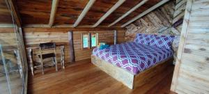 ChordelegCabaña Lato_puzhio的小木屋内一间卧室,配有一张床