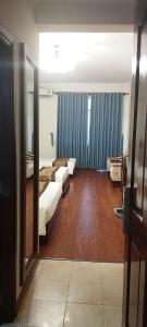 胡志明市Ngọc Lan Hotel的一间卧室设有两张床,铺有木地板