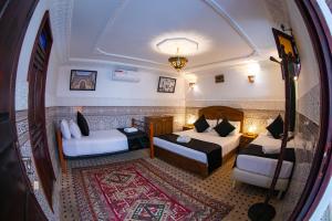 非斯Dar Amir Fez的客房享有带两张床和地毯的客房的景致。